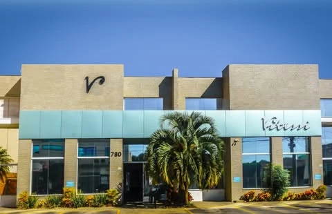 Fachada real da Clínica Vitessi em Indaiatuba, com jardim e entrada envidraçada