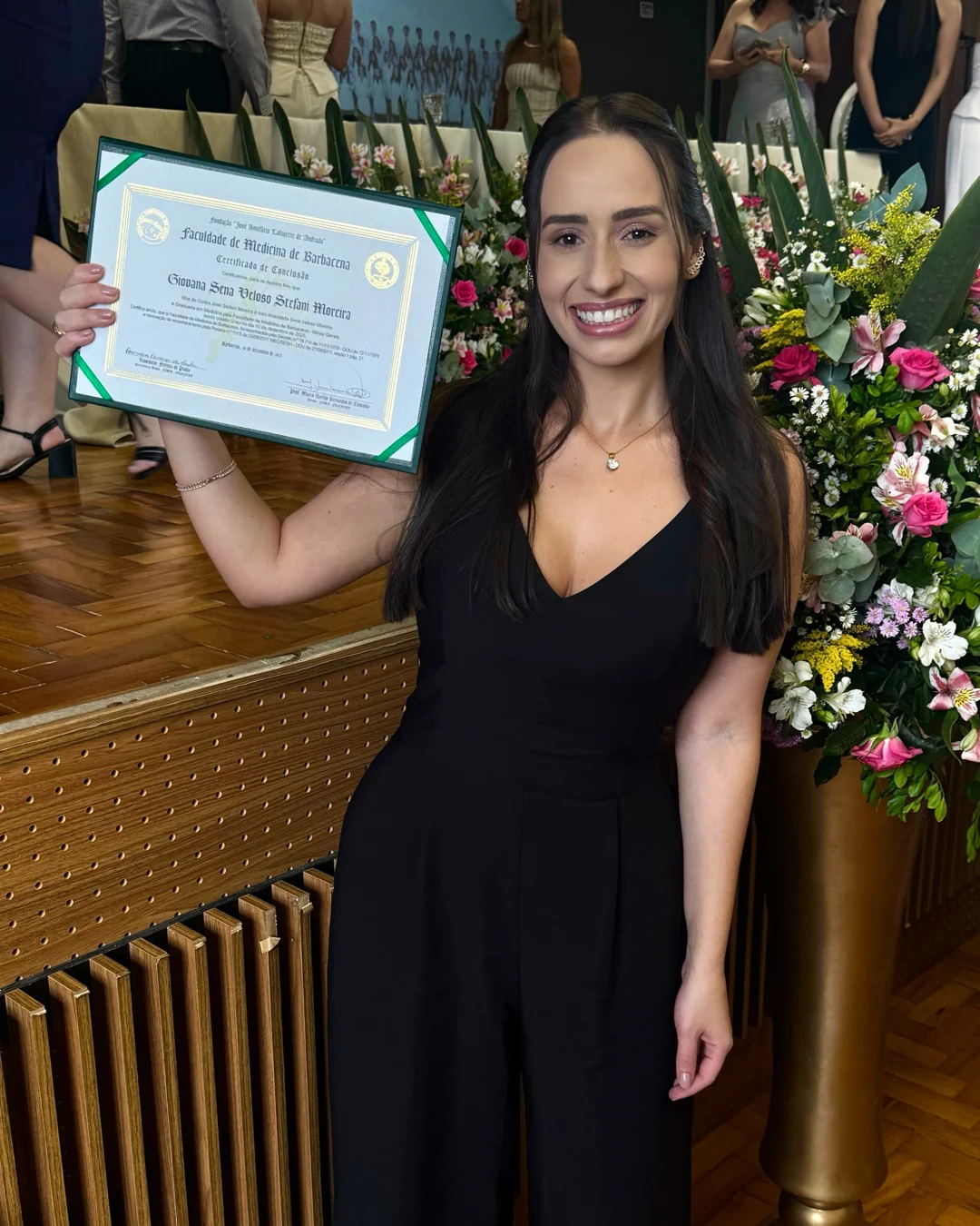 Giovana na cerimônia de formatura, segurando seu certificado da Faculdade de Medicina de Barbacena