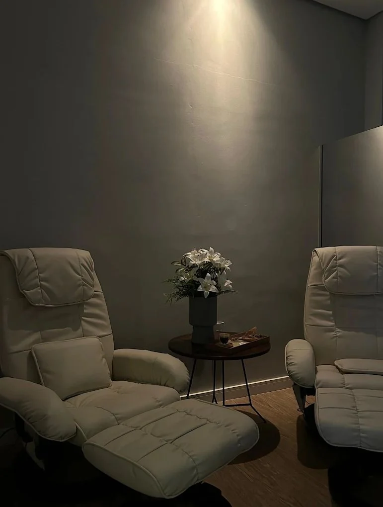 Ambiente de espera da Clínica Vitessi com poltronas claras e uma mesa de flores